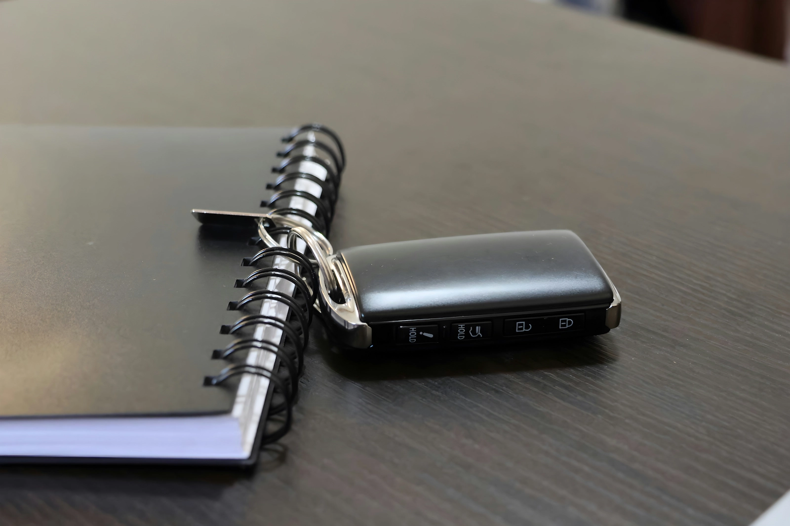 Modern car key fob placed on a desk before battery replacement